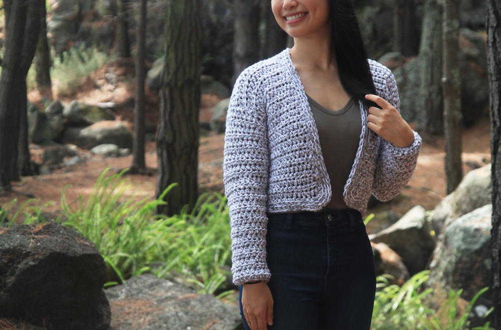 easy merino cropped crochet cardigan with forest background