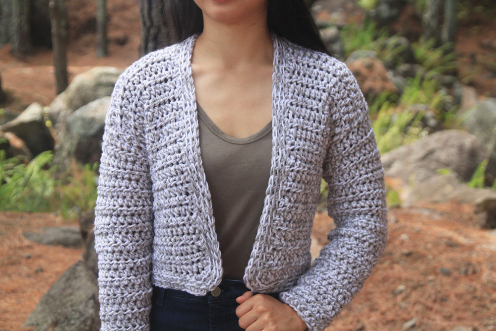 close up of marled white and grey crochet crop sweater 