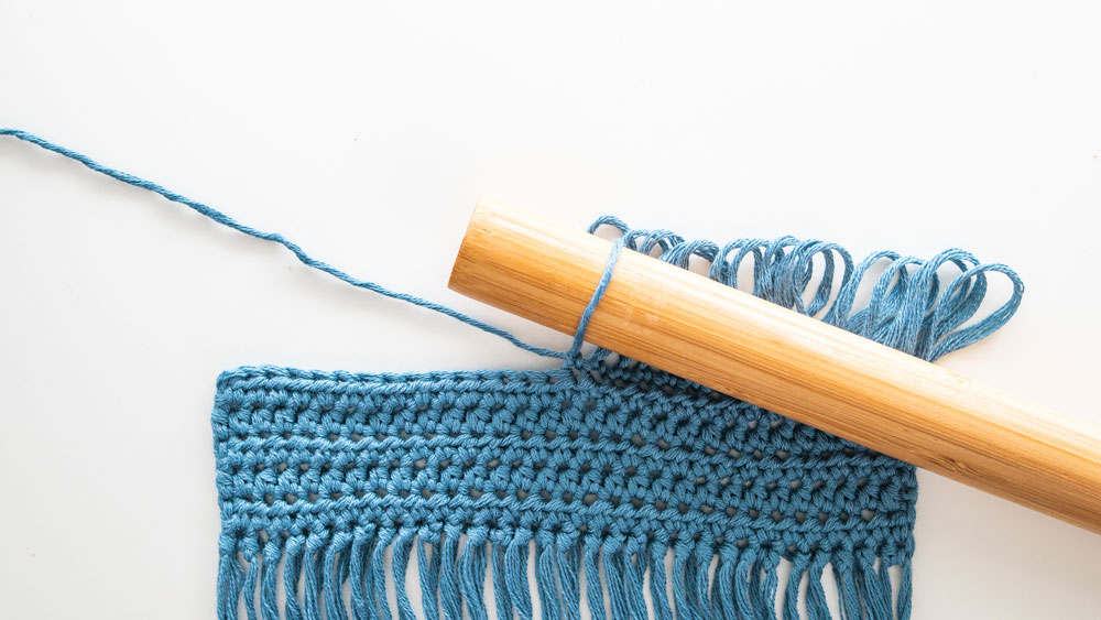 pull on yarn to tighten crochet loop on dowel