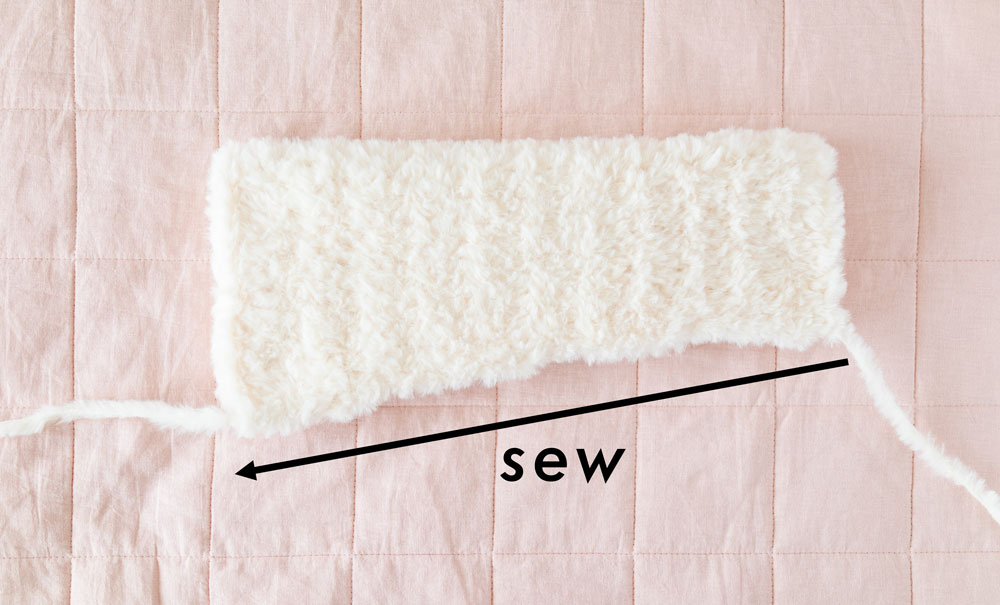 fluffy crochet sleeve folded in half to be sewn along long edge