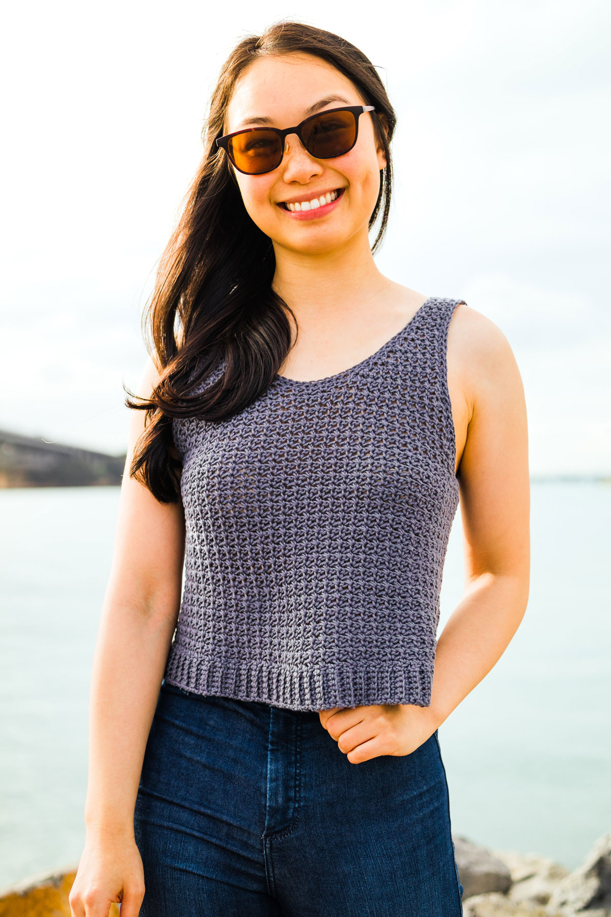 model wearing mesh crochet singlet with sunglasses and dark denim jeans
